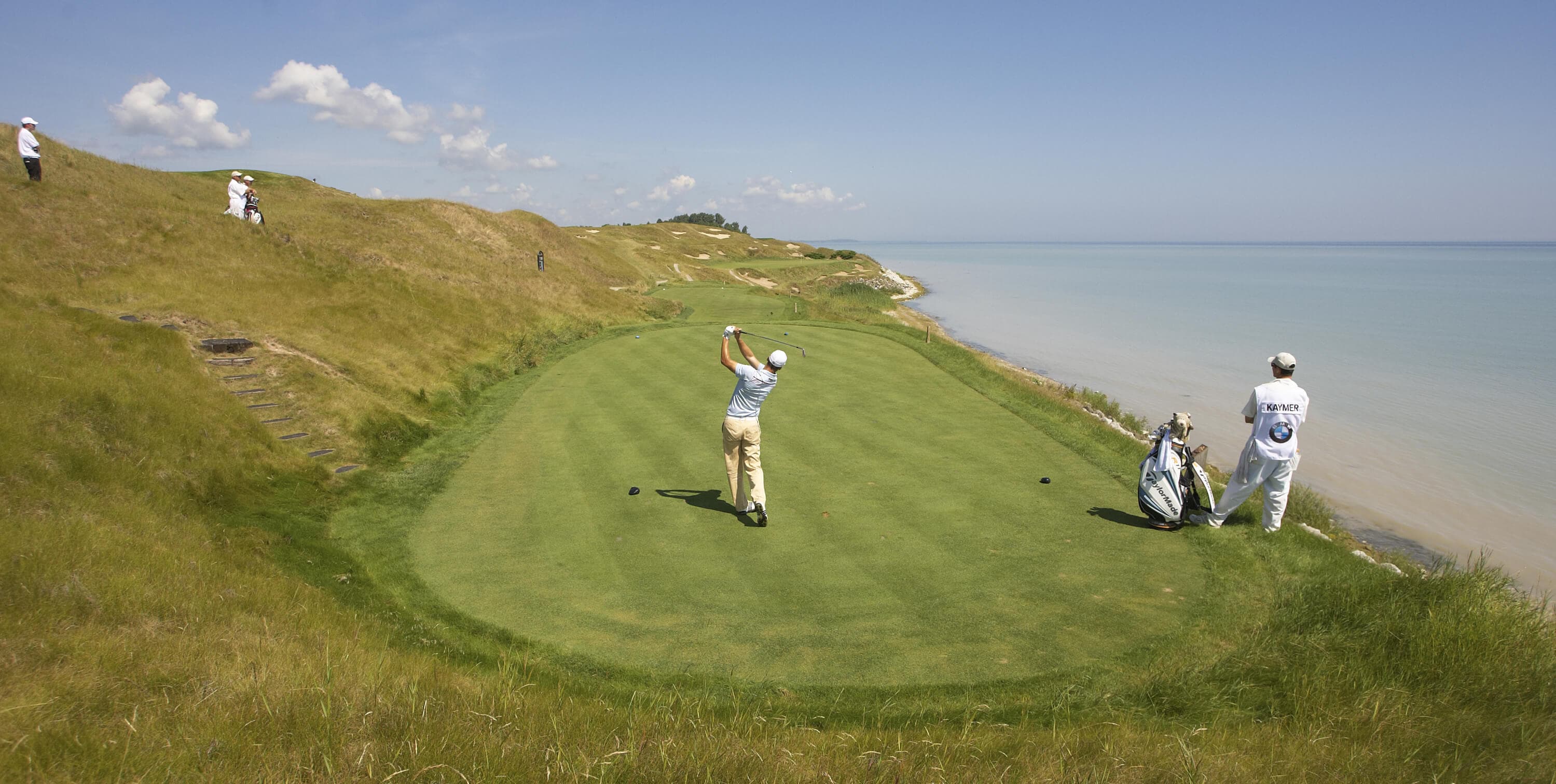 Golfers on a links course beside the water